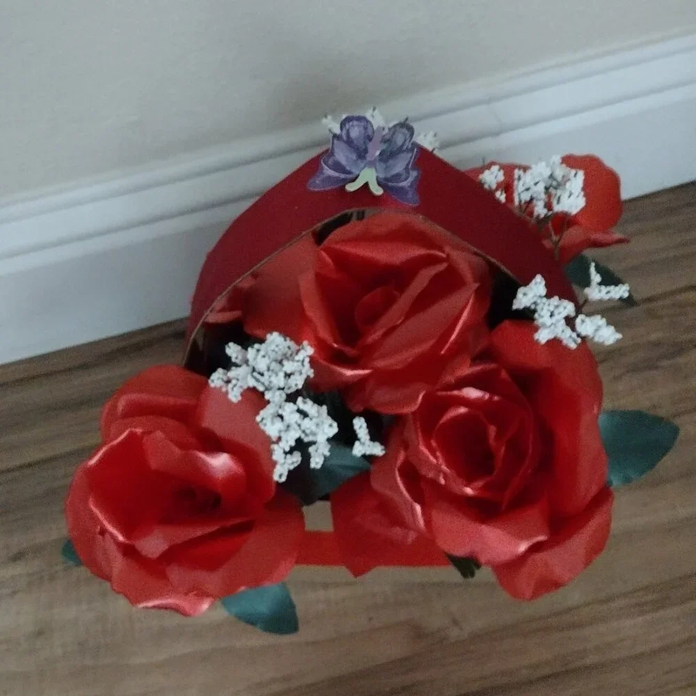 Handmade floral arrangement with plastic ribbon roses.